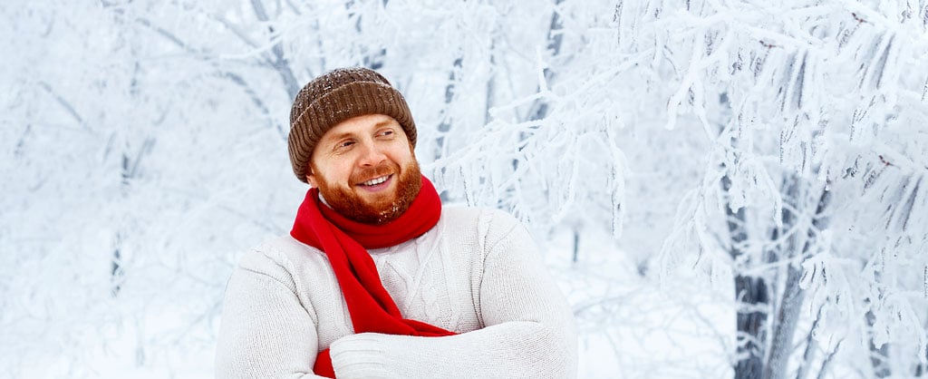 Mann mit Schal und Mütze im Schnee