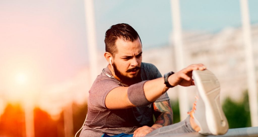 ein mann stretcht sein bein