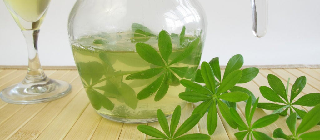 Ein Glas gefüllt mit einer Maibowle