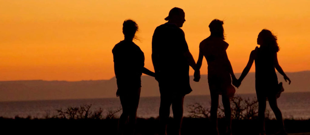 Eine Familie im Sonnenuntergang am See