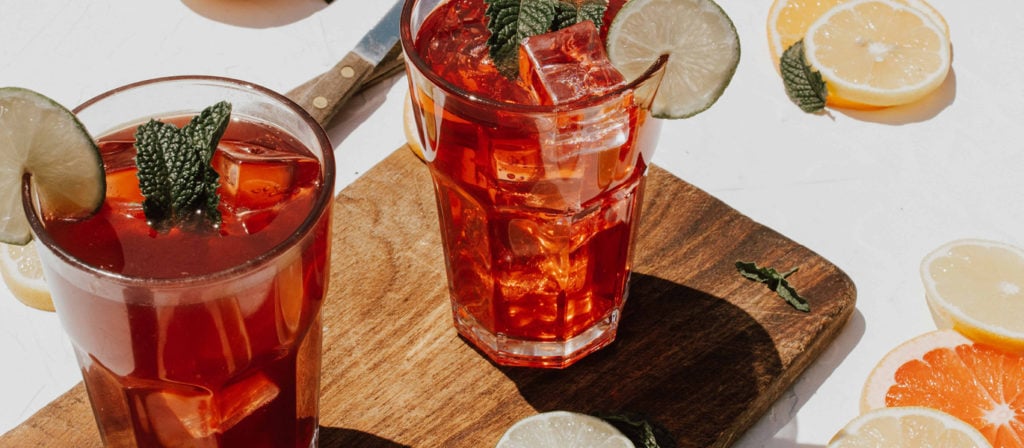 Zwei Gläser stehen nebeneinander mit einem roten Cocktail