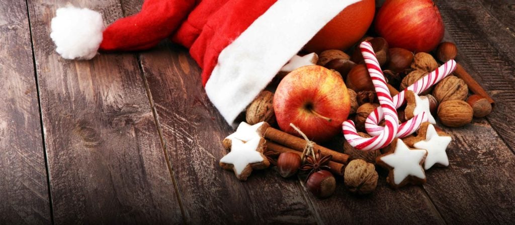 Weihnachtsmannmütze mit Äpfeln und Nüssen drin