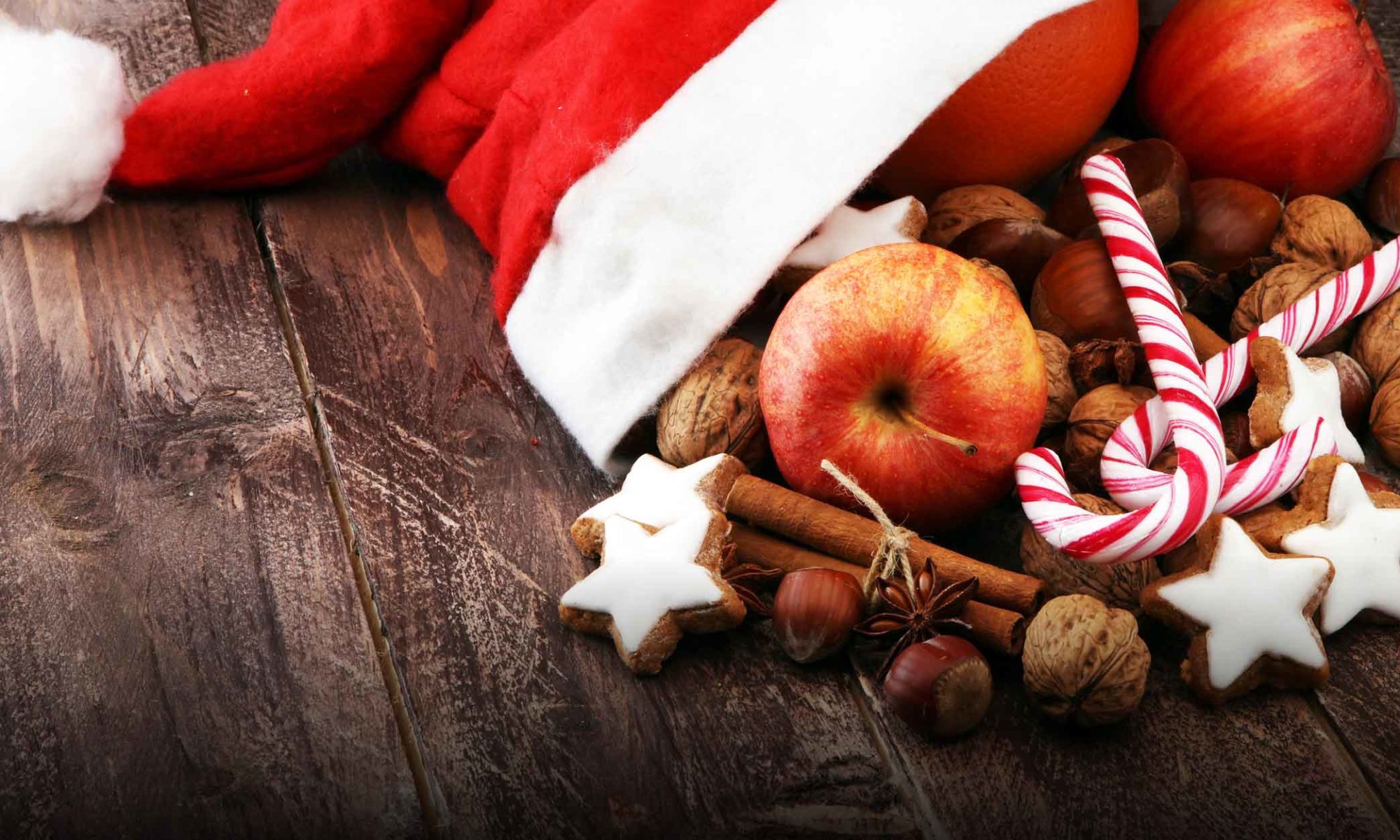 Weihnachtsmannmütze mit Äpfeln und Nüssen drin