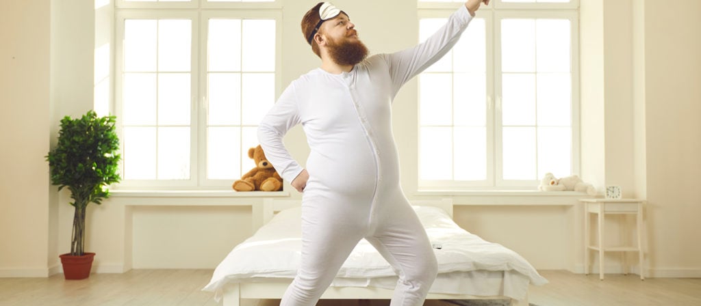 Dicker Mann macht Dehnübungen im Schlafzimmer