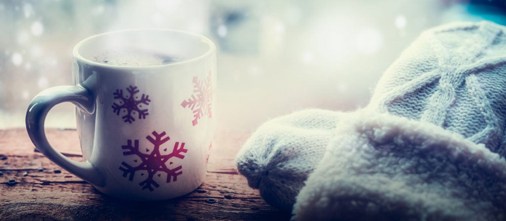 Eine Tasse mit einem heißen Getränk steht auf dem Fensterbrett
