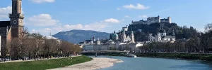 Blick von der Salzach auf die Festung Hohensalzburg, die Alte Residenz und die historische Altstadt von Salzburg.