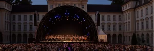 Bühne und Publikum im beleuchteten Innenhof des Schlosses