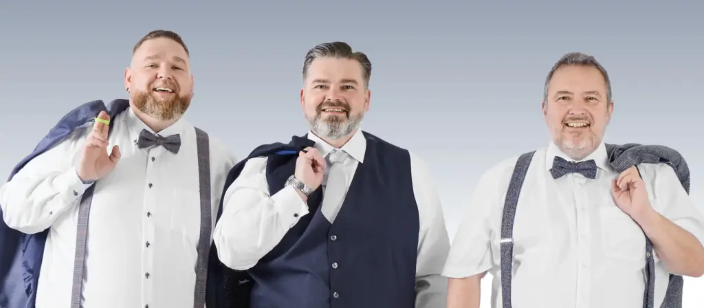 Drei Männer in großen Größen tragen festliche Anzüge und Sakkos, lächeln selbstbewusst in die Kamera und zeigen stilvolle Herrenmode von Pfundskerl.