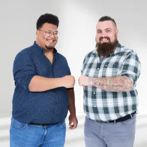 Zwei kräftige Männer in Freizeitmode grüßen sich mit Faustcheck – Plus Size Mode mit Charakter und Echtheit.