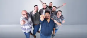 Gruppe echter Pfundskerl-Models zeigt lachend auf die Kamera