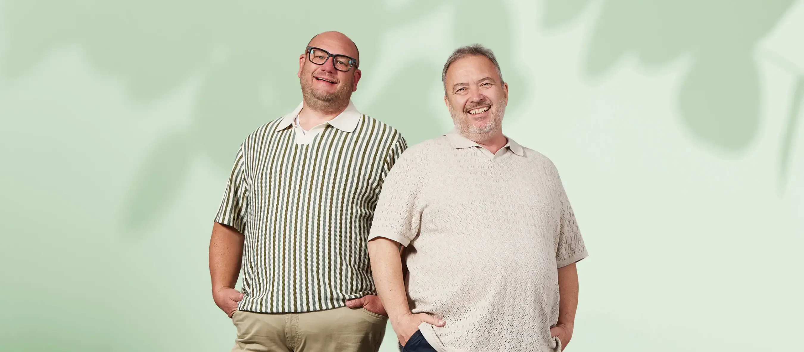 Zwei Männer in großen Größen präsentieren moderne Strickpoloshirts in sommerlichen Farben und Mustern.