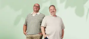 Zwei Männer in großen Größen präsentieren moderne Strickpoloshirts in sommerlichen Farben und Mustern.