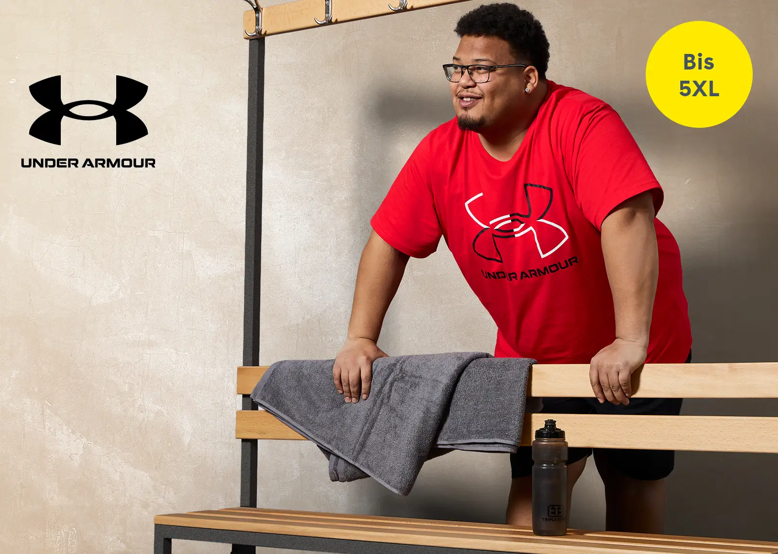 Mann in großer Größe mit rotem Under Armour Shirt in einer Umkleide – Trainingsbekleidung bis 5XL