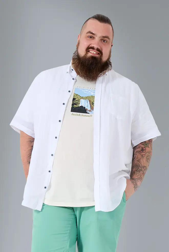 Plus Size Model trägt offenes weißes Hemd über Printshirt und mintgrüner Hose