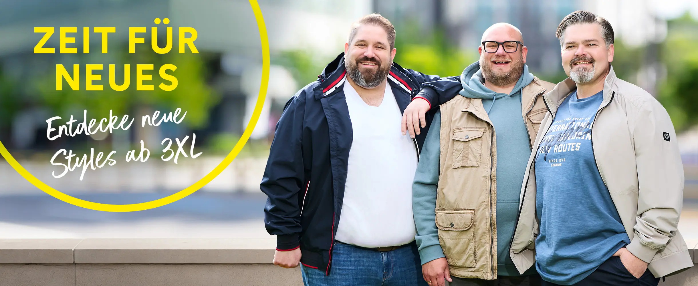 Drei Männer in Übergangsjacken stehen lächelnd nebeneinander im Freien