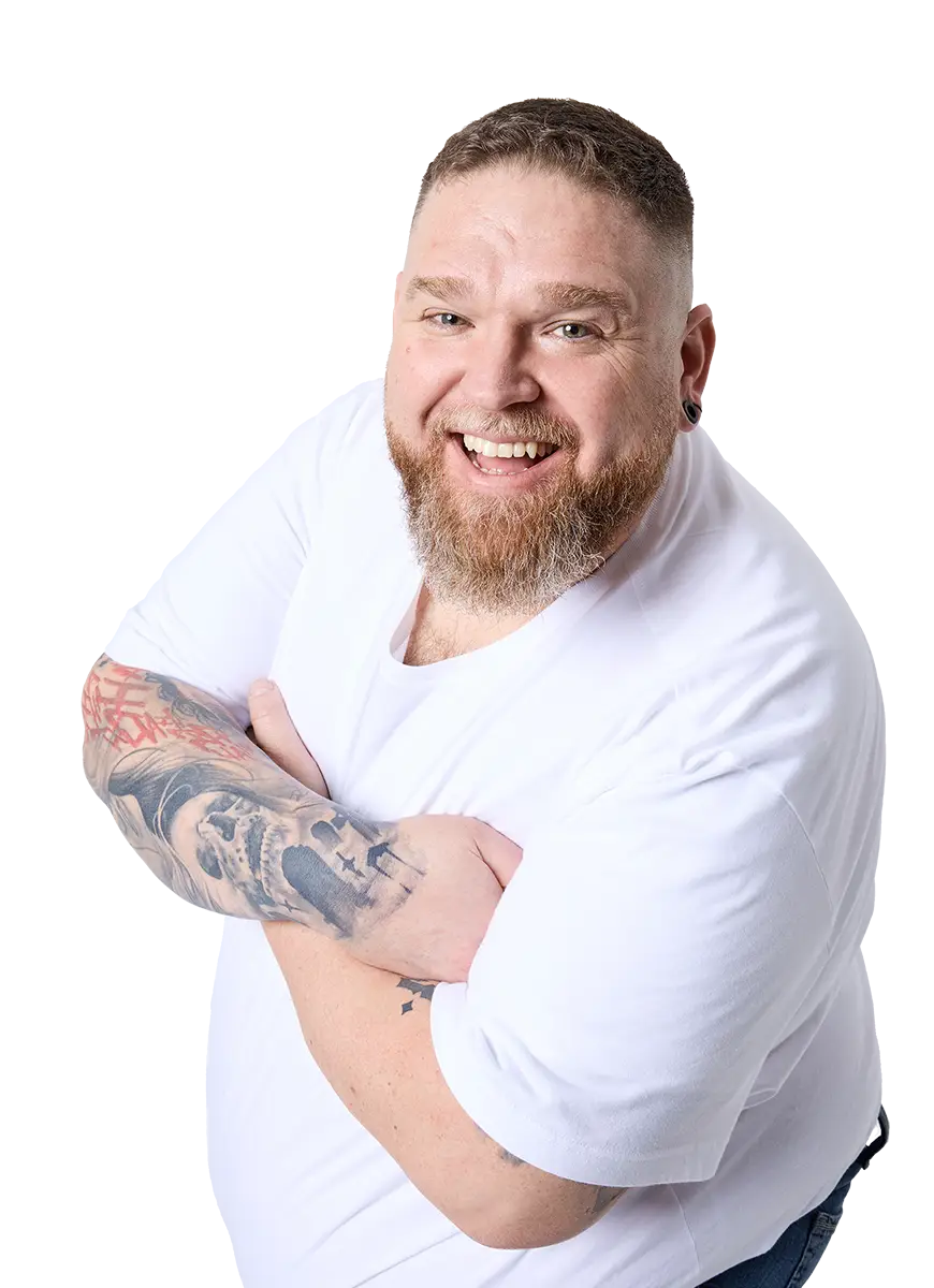 Lachender Mann mit Bart und Tattoos in weißem T-Shirt – Plus Size Model bei Pfundskerl