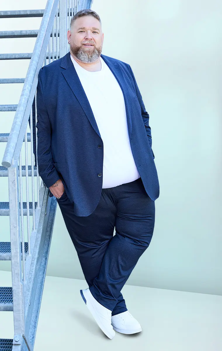 Mann im dunkelblauen Jersey-Anzug mit weißem Shirt – sportlich-schicker Plus-Size-Style