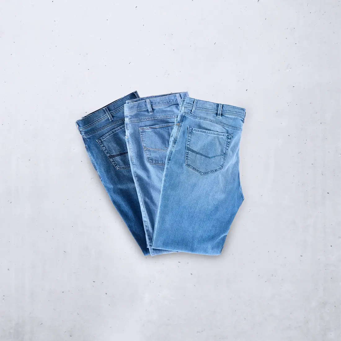 Gefaltete Herren-Jeans in verschiedenen Blautönen für starke Männer in großen Größen