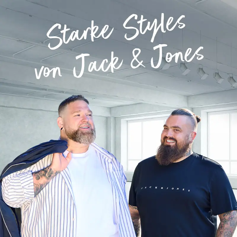Zwei kräftige Männer in Jack & Jones Outfits – einer im gestreiften Hemd mit Sakko, der andere im schwarzen T-Shirt mit Logo.