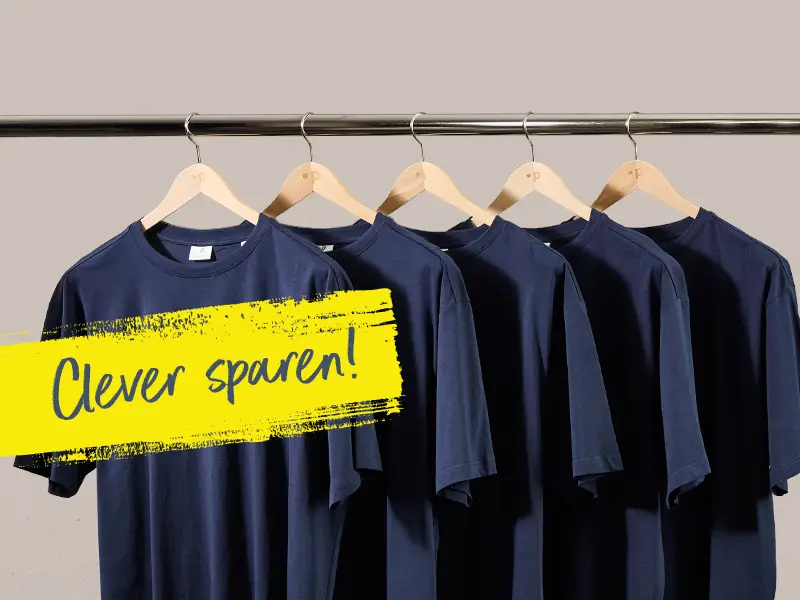 Mehrere dunkelblaue T-Shirts in großen Größen hängen auf einer Stange mit Hinweis auf clever sparen.