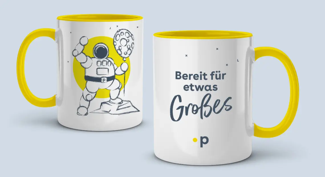 Zwei weiße Sammeltassen mit gelbem Henkel und Innenfläche: Eine zeigt einen Astronauten mit einem ballonförmigen Mond vor gelbem Kreis, die andere trägt den Schriftzug ‚Bereit für etwas Großes.‘ mit gelbem Punkt und dem Buchstaben ‚p‘.