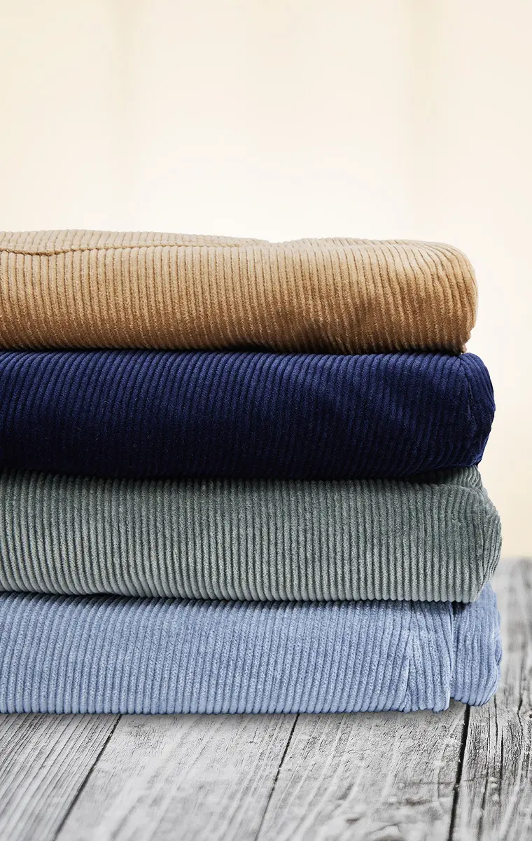 Vier farbige Cordhosen in großen Größen, gefaltet in weichem Feincord