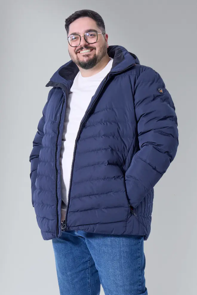 Mann mit großer Größe trägt blaue Steppjacke und weißes Shirt – Herbstmode für draußen