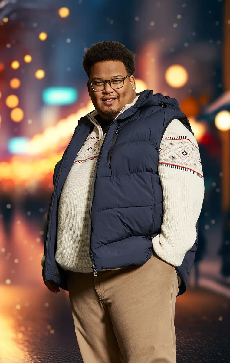 Mann mit Steppweste und Strickpullover im winterlichen Outdoor Weihnachtsstyle