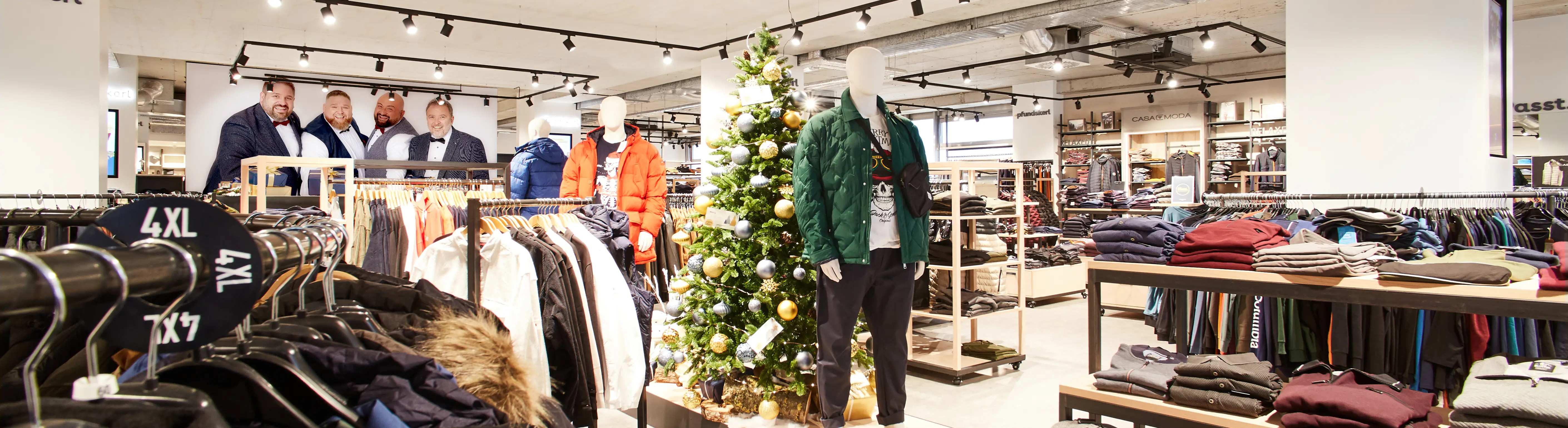 Präsentation von Winterjacken und Strickteilen auf Mannequins und Kleiderstangen