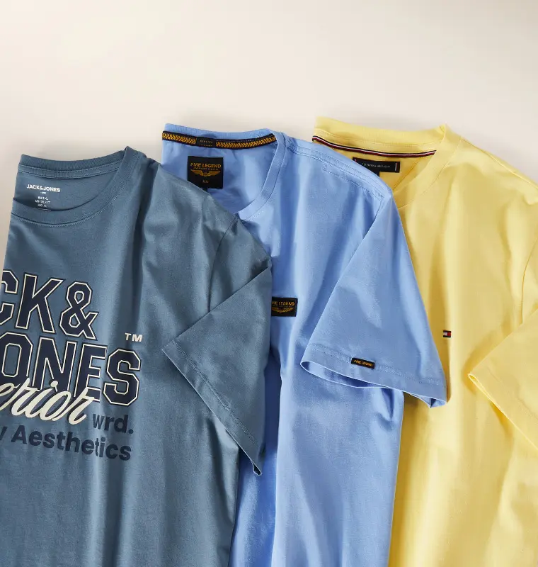 Mehrere T-Shirts in Blau- und Gelbtönen nebeneinander ausgelegt