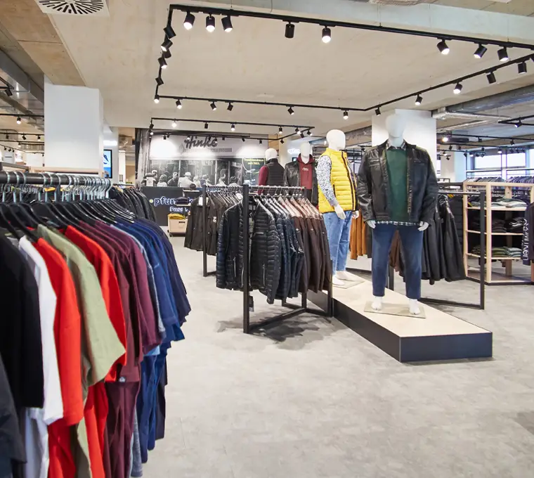 Moderne Präsentation von Jacken, Jeans und Übergrößen-Mode im Pfundskerl Store mit ausgestellten Looks