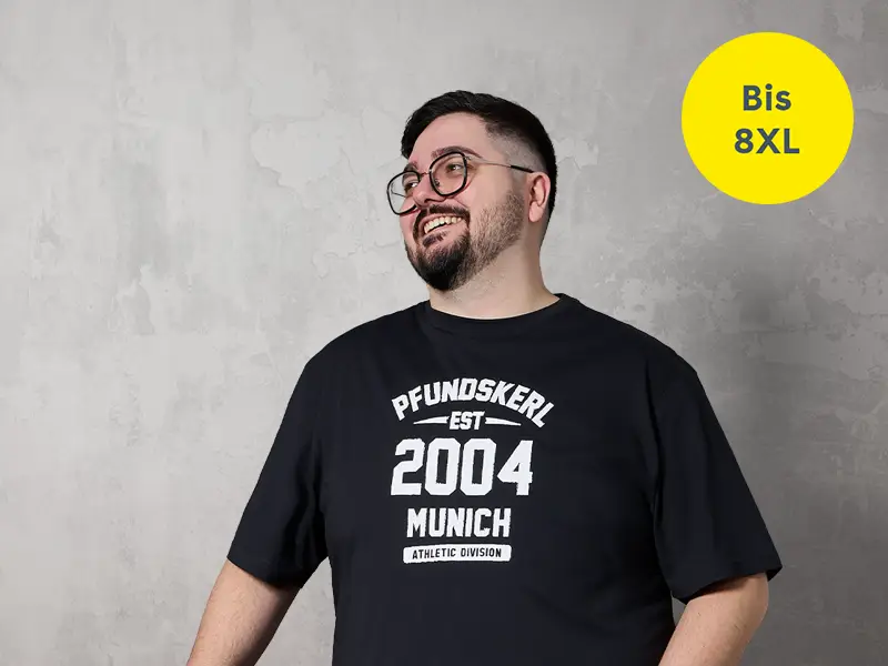 Starker Mann trägt schwarzes T-Shirt in großen Größen bis 8XL mit angenehmer Passform und modernem Stil.