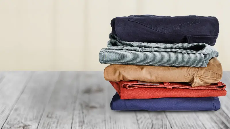 Gestapelte Herren-Hosen in verschiedenen Farben aus der Übergrößen-Kollektion.