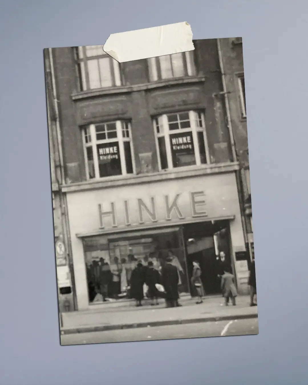 Historische Außenansicht des Hinke Modehauses in München mit Schaufenstern und Kunden vor dem Geschäft.