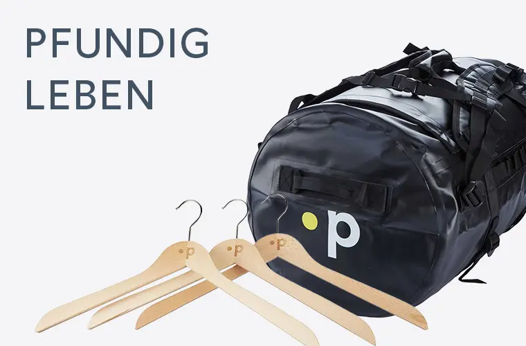 Schwarze Reisetasche mit Pfundskerl-Logo und Kleiderbügel als Symbol für Lifestyle
